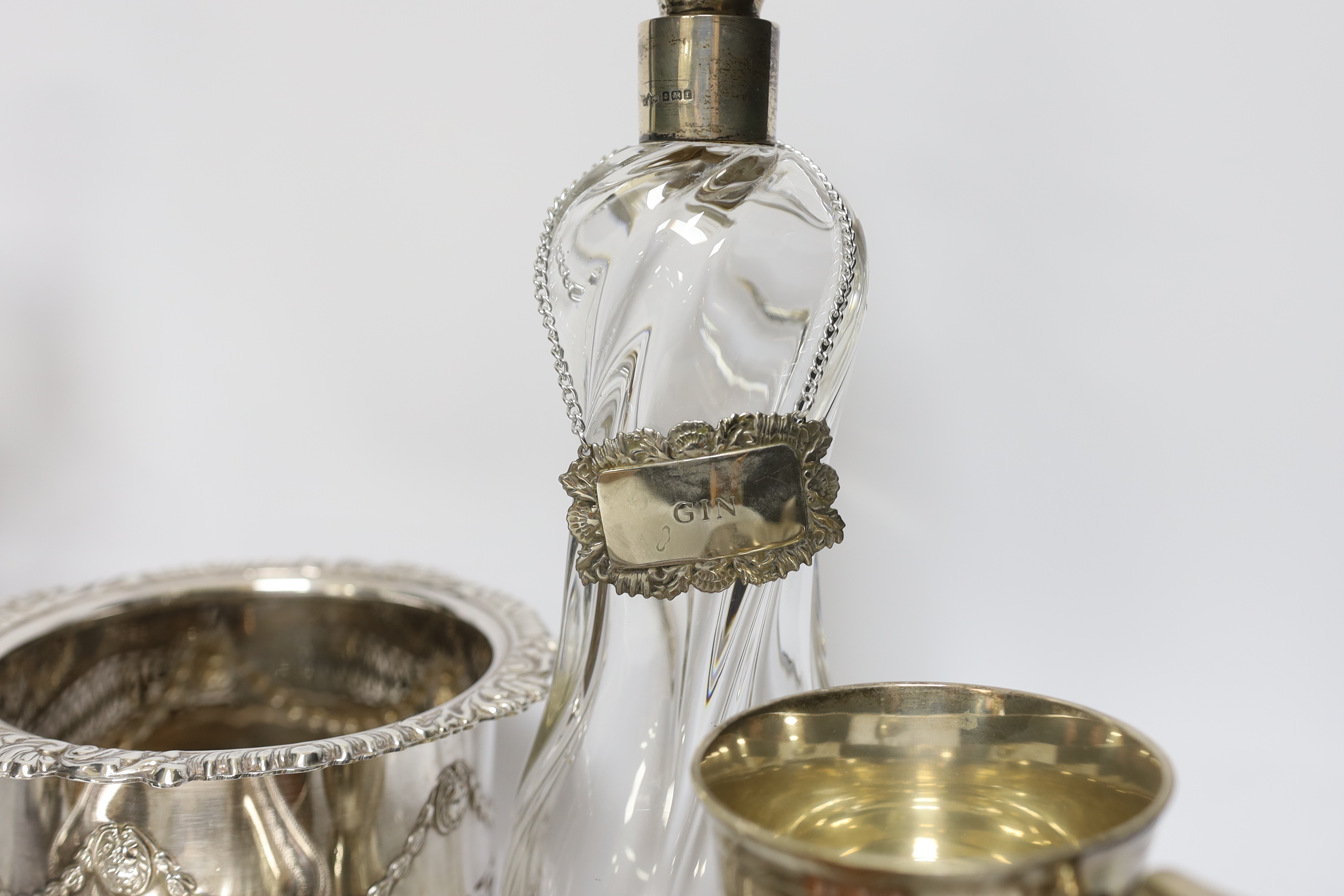 Two decanters; one with silver mount and one with etched body, together four wine coasters, a bucket raised on four feet, etc.